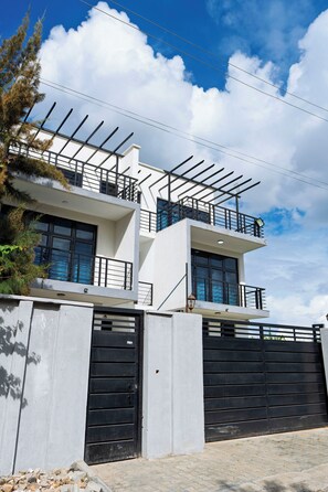 Ein modernes, zweistöckiges Gebäude mit Balkon, großen Fenstern und einem verschlossenen Eingang.