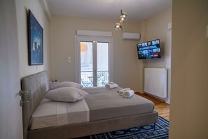 A bedroom with a bed, a TV, a window, and a radiator. - Luxury Modern 2 bed Elegance (Athina)