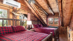 Une cabine avec deux lits, une fenêtre et un poisson empaillé accroché au mur.