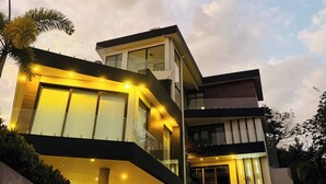 Une maison moderne à plusieurs étages, dotée de grandes fenêtres et d’un escalier.