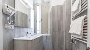 A modern bathroom with a sink, mirror, and towel rack. - La Casa di Lidia - Vatican City  (Rome)