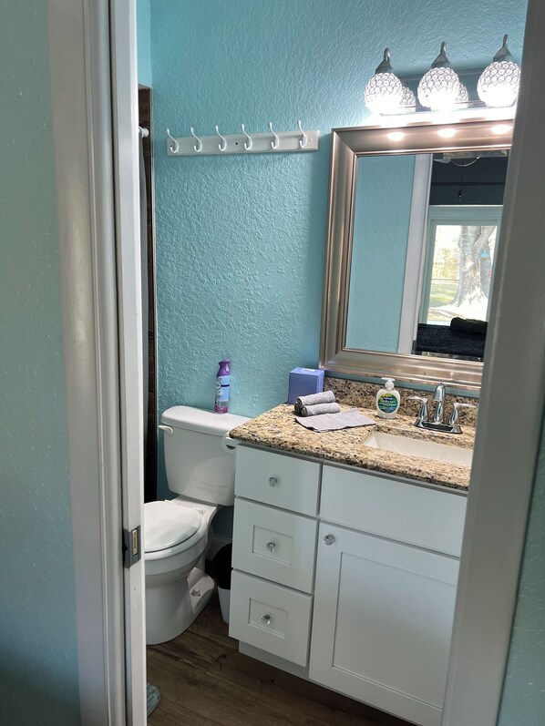 A bathroom with a toilet, sink, and mirror.