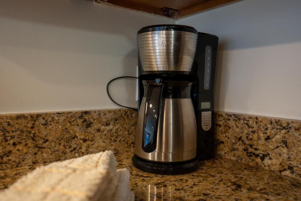 Une machine à café posée sur un plan de travail en granit.