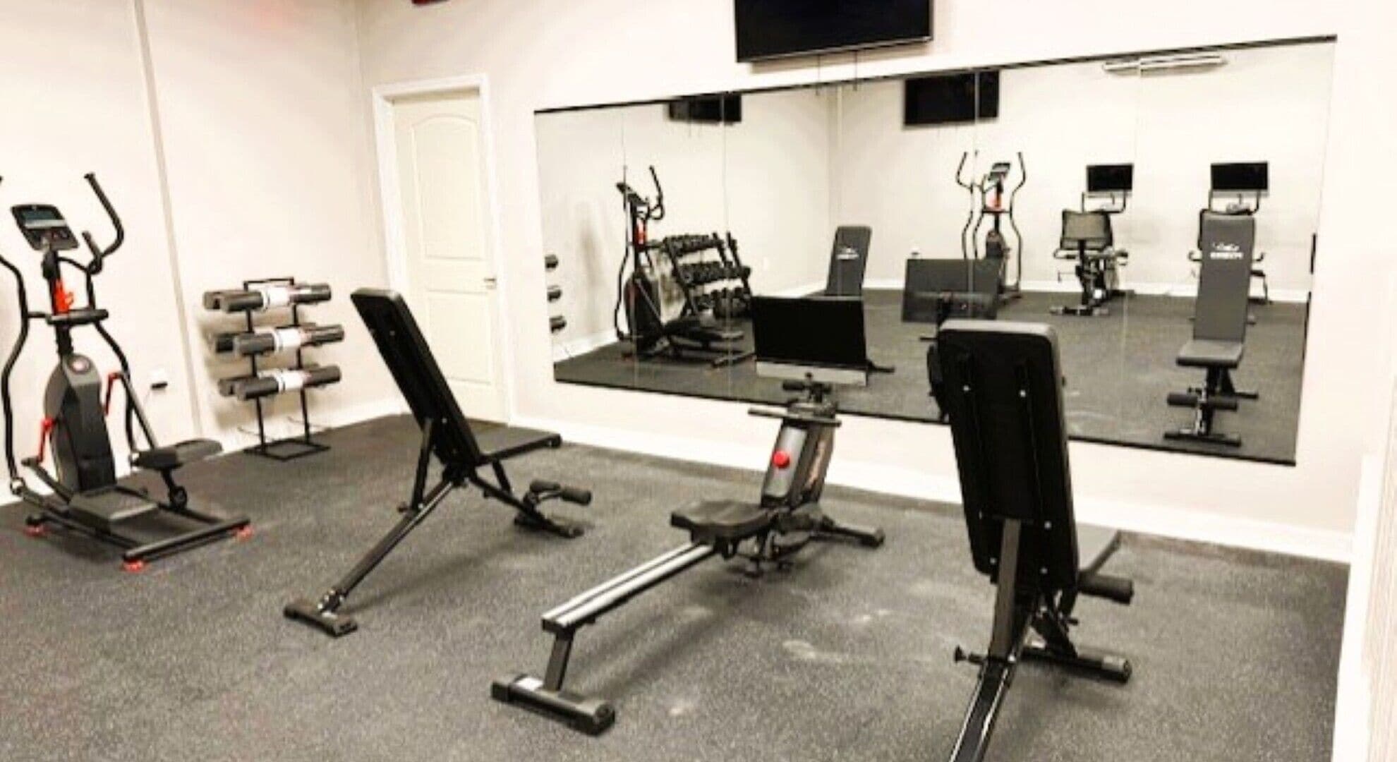 A gym with stationary bikes, a treadmill, and weight machines.