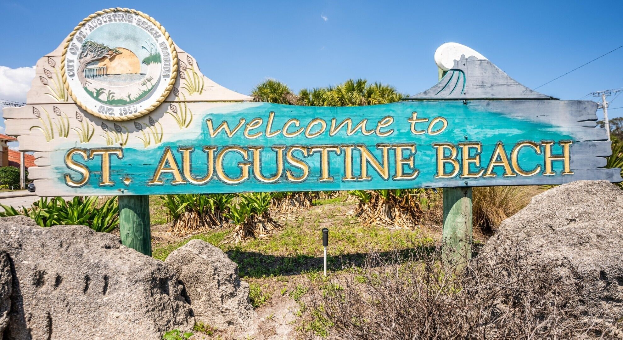 A welcome sign to St. Augustine Beach with a seal and a wave design.