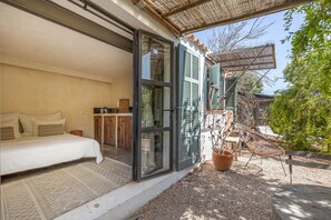 Un dormitori amb llit, una nitòria i una finestra amb vista a l'exterior.