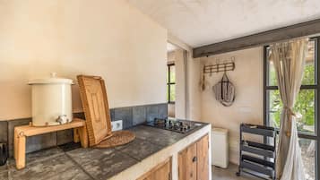 Een keuken met een inbouwfornuis, een spoelbak en een grote witte waterdispenser.