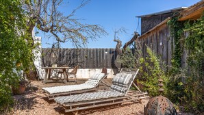 A patio with two lounge chairs, a table, and chairs. - Rural House 'Sa Caseta Mallorca Studio' with Mountain Views, Shared Pool and Wi-Fi (Algaida)