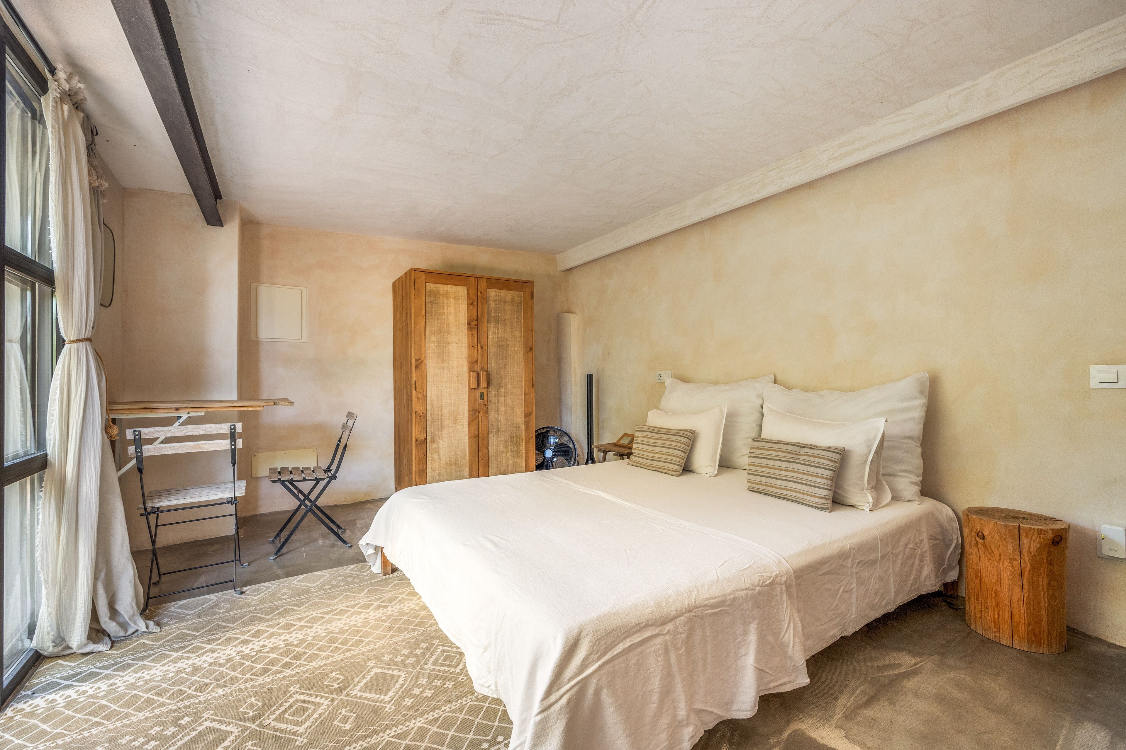 Een slaapkamer met een bed, een bureau en een stoel.