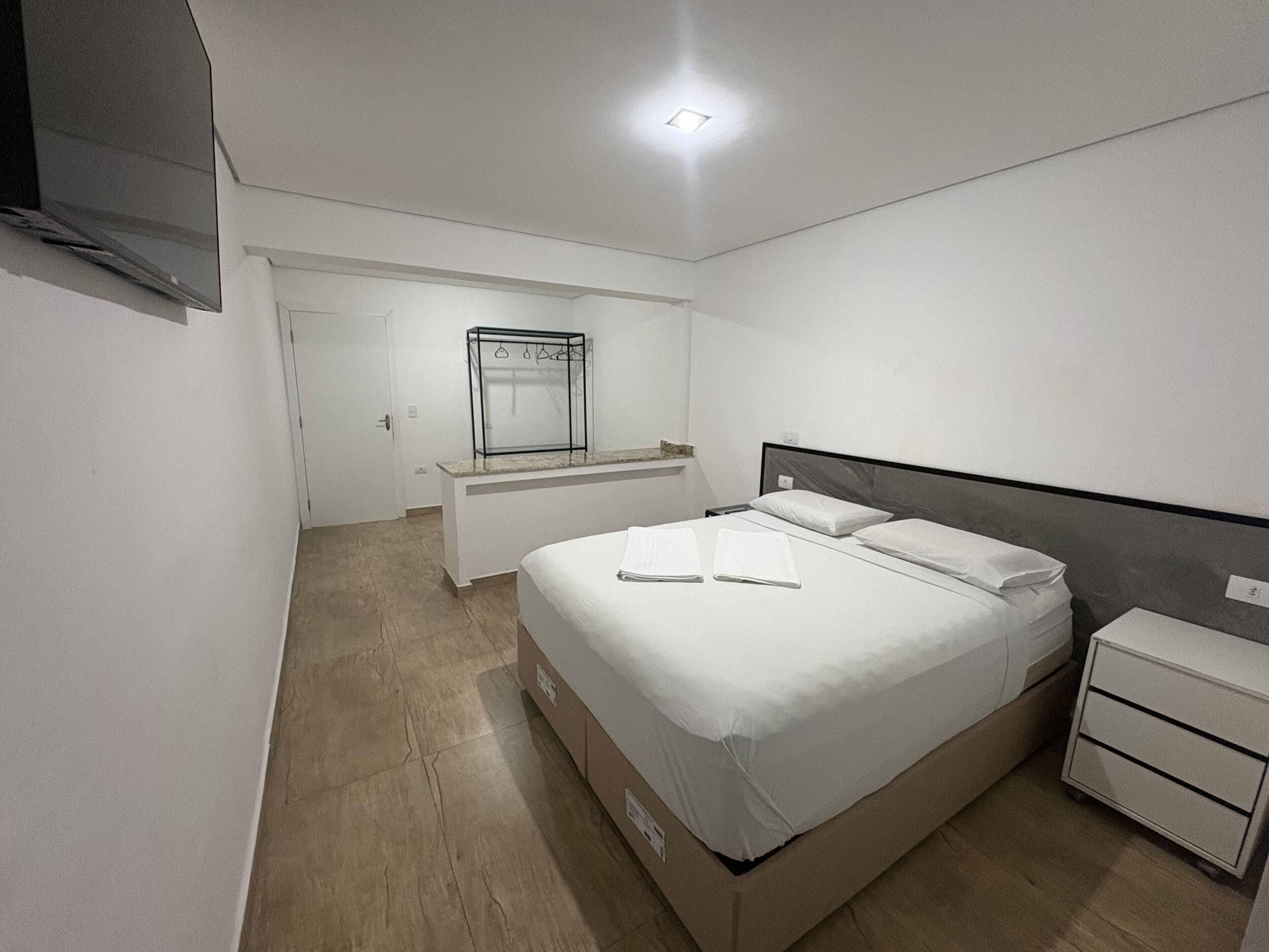 A bedroom with a bed, bedside table, and a built-in wardrobe.