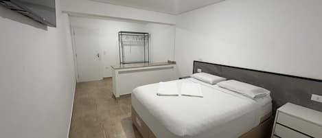 Un dormitorio con cama, mesita de noche y armario empotrado.