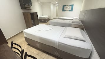 A hotel room with two beds, a TV, a desk, and a wardrobe.