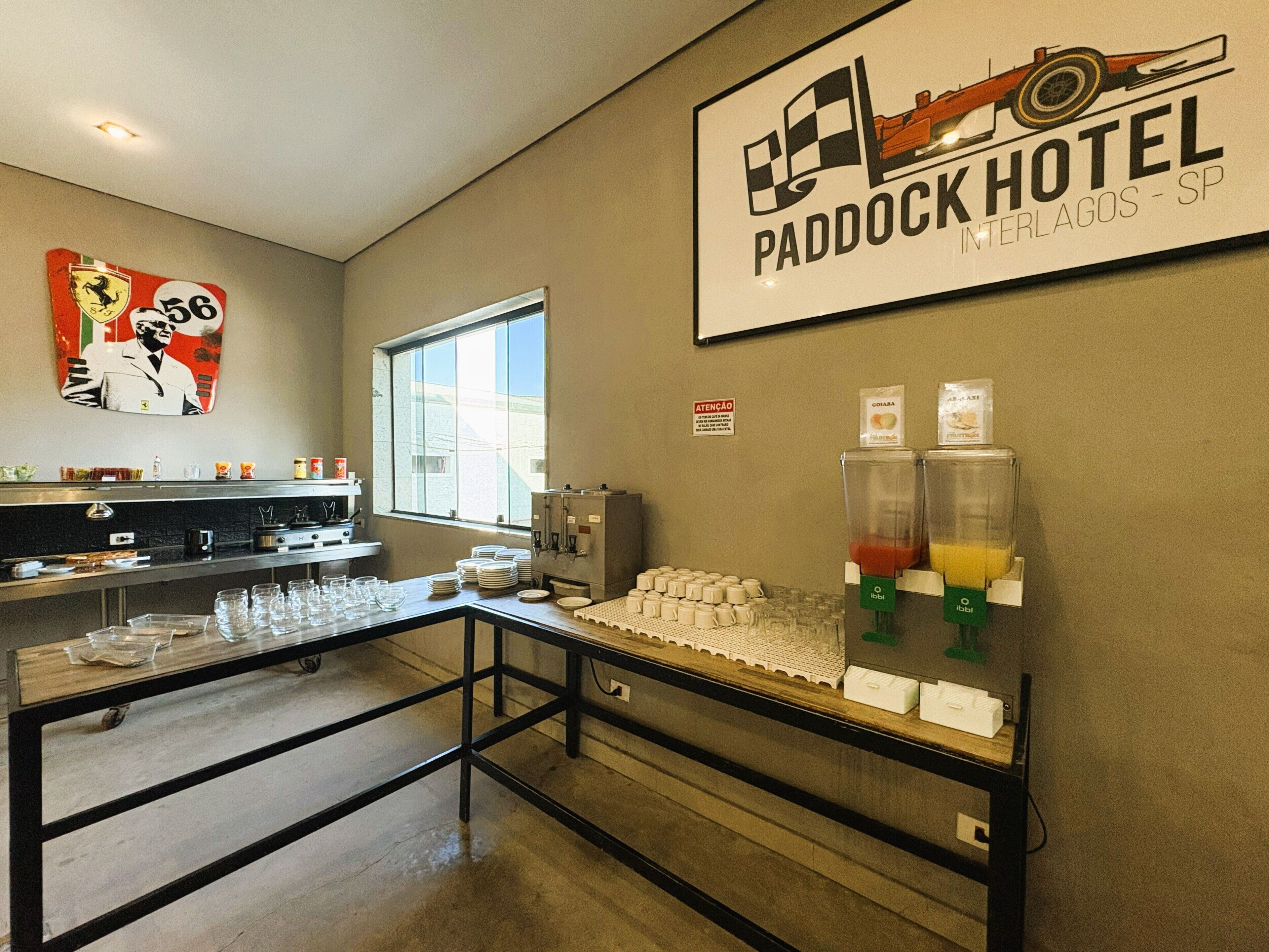 Mostrador de desayuno con estación de bebidas, una ventana y un letrero en la pared para Paddock Hotel Interlagos - SP.