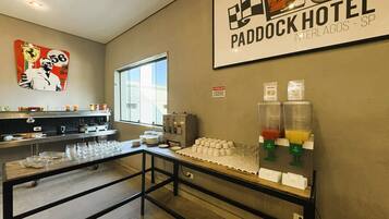 Mostrador de desayuno con estación de bebidas, una ventana y un letrero en la pared para Paddock Hotel Interlagos - SP.