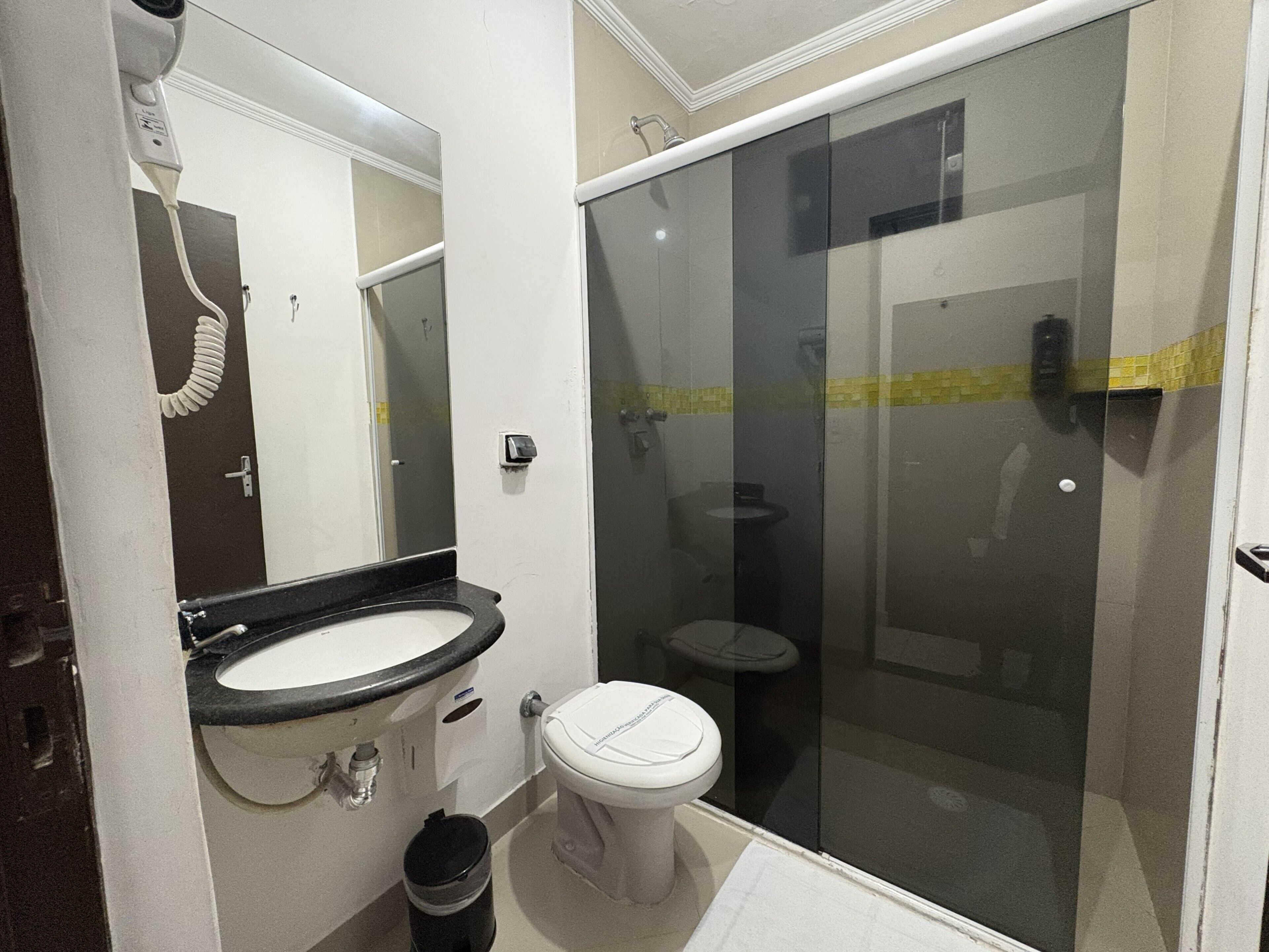 A bathroom with a sink, toilet, and a glass-enclosed shower area.