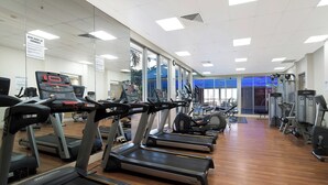 Een sportschool met loopbanden, elliptische trainers en gewichtstoestellen.