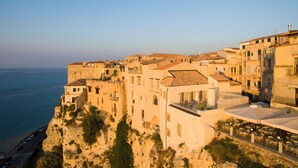A coastal town with buildings along the cliffside, overlooking the sea. - TROPEA VETERA Luxury Home - Oven House 1638 (Tropea)