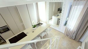 A modern kitchen with a central island, white chairs, and a view of the dining area. - TROPEA VETERA Luxury Home - Oven House 1638 (Tropea)