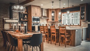 A modern kitchen with wooden cabinets, a central island, and pendant lighting.