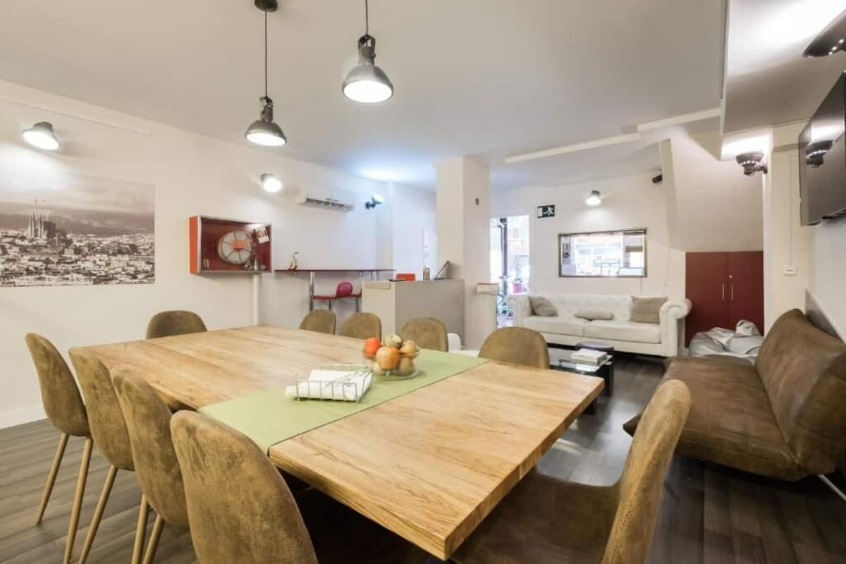 A modern living space with a dining area, kitchen, and seating area.