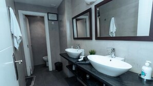 Ein modernes Badezimmer mit zwei Waschbecken, einer Toilette und einer Dusche.