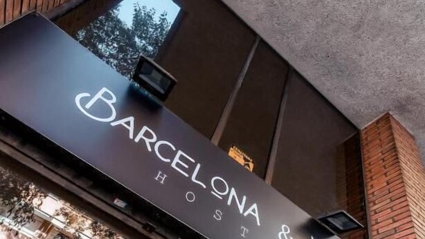 Ein Hotelschild mit dem Schriftzug 'Barcelona & You', das auf ein Hostel hinweist.