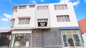 A hotel with a signboard, large windows, and a tiled entrance. - Hotel O Pradhan Nagar Prince Guest House (Siliguri)