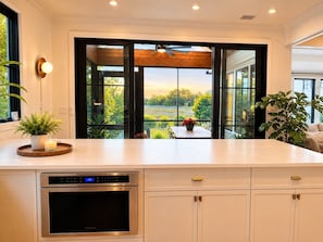 Una cocina moderna con horno integrado, comedor con vistas y un amplio ventanal.