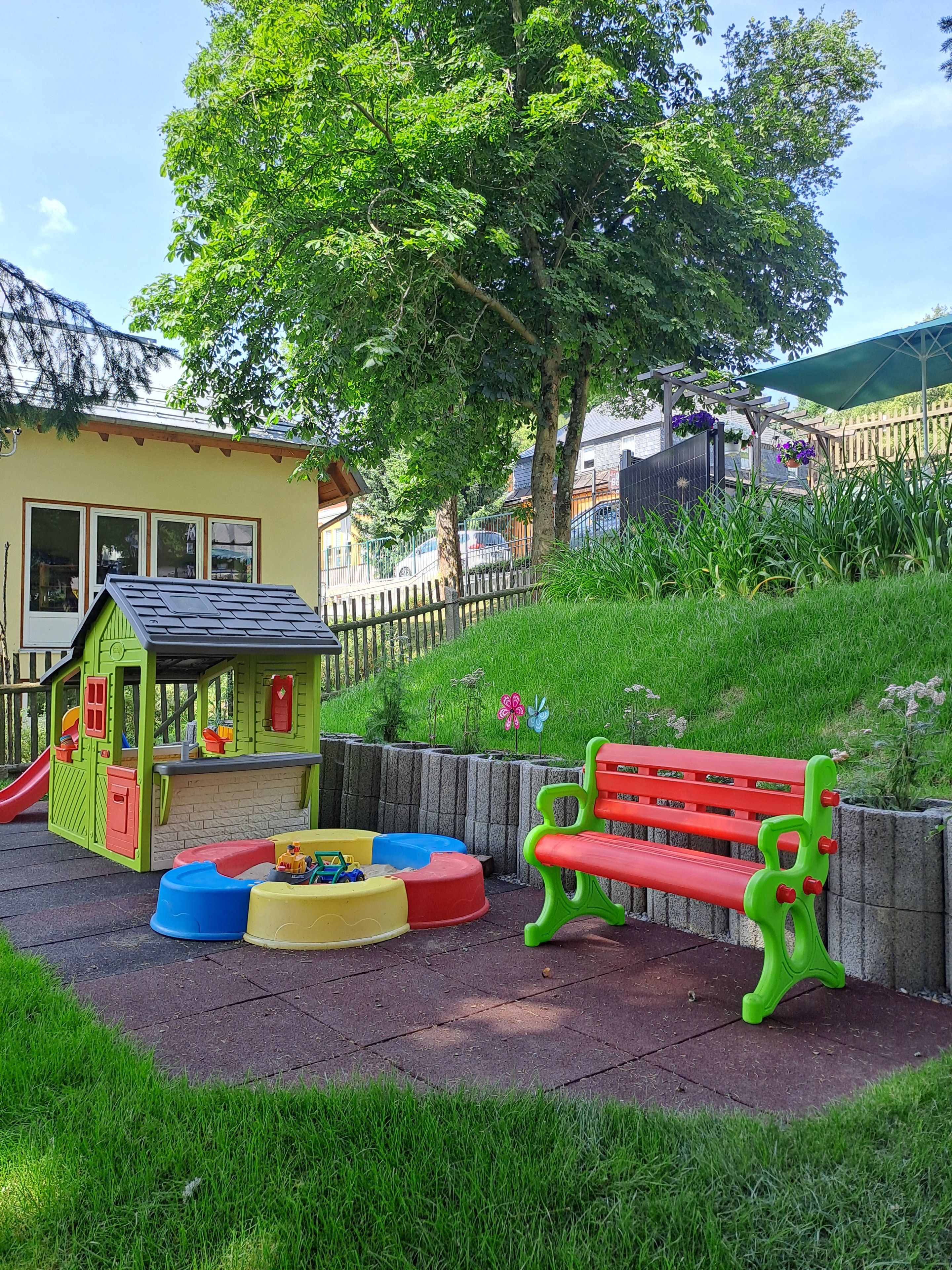 A children's play area with a slide, playhouse, and colorful play structures.