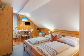 A cozy room with a bed, a desk, and a chair. - Pension Kaufmann / Holiday Apartment for 1–3 Guests in Oberwiesenthal (Oberwiesenthal)