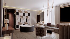 A modern bathroom with a bathtub, vanity, and seating area.