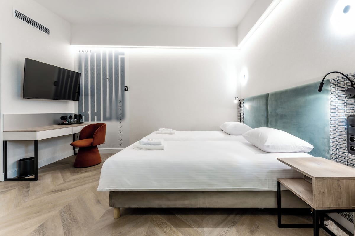 Een moderne hotelkamer met een bed, een bureau, een stoel, een televisie en een douche.