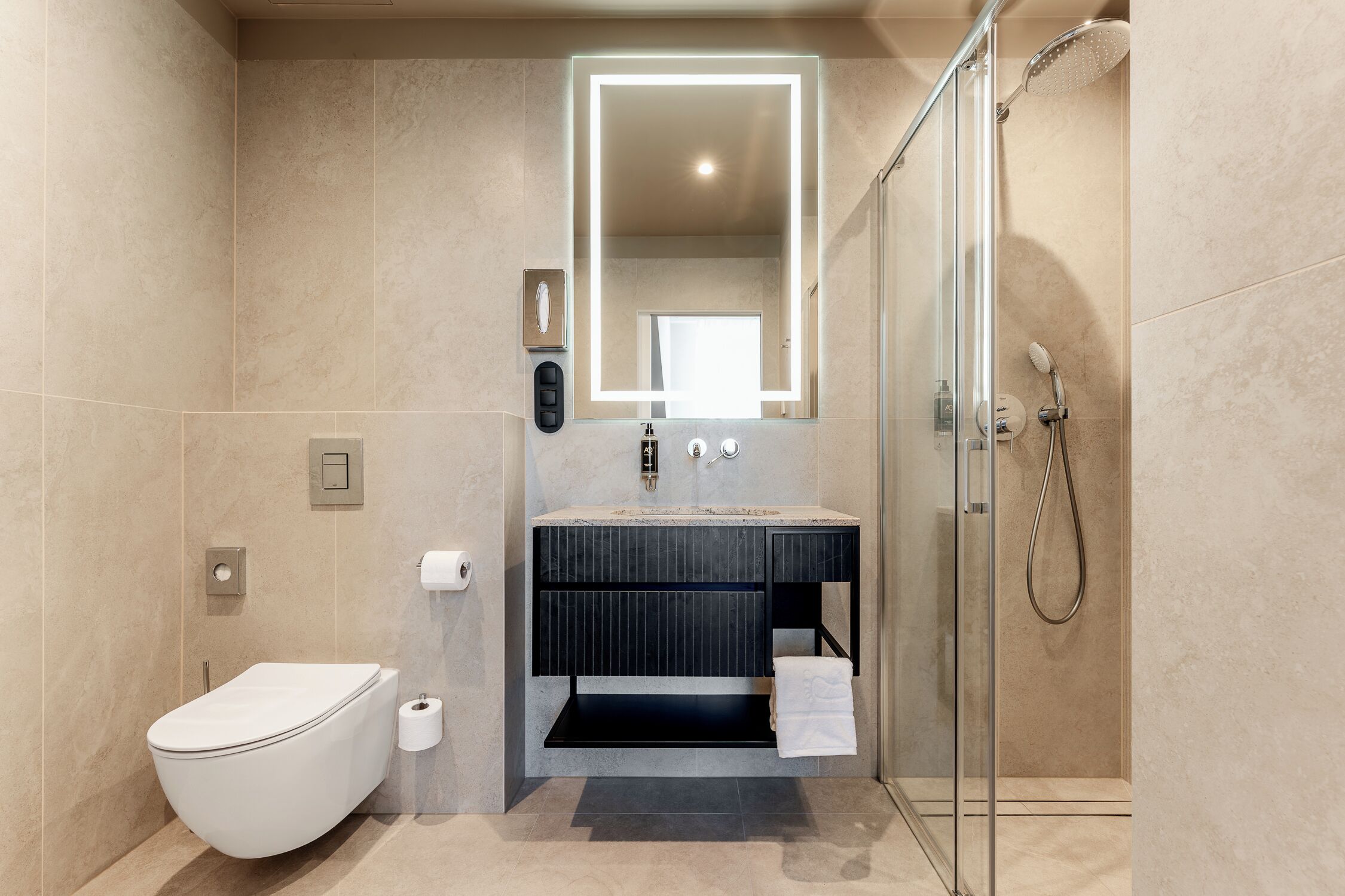 Ein modernes Badezimmer mit Toilette, Waschbecken, Spiegel und Dusche.