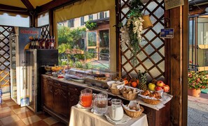 Un buffet de petit-déjeuner proposant une variété d’aliments, un espace dédié aux boissons et une vue sur l’espace extérieur.