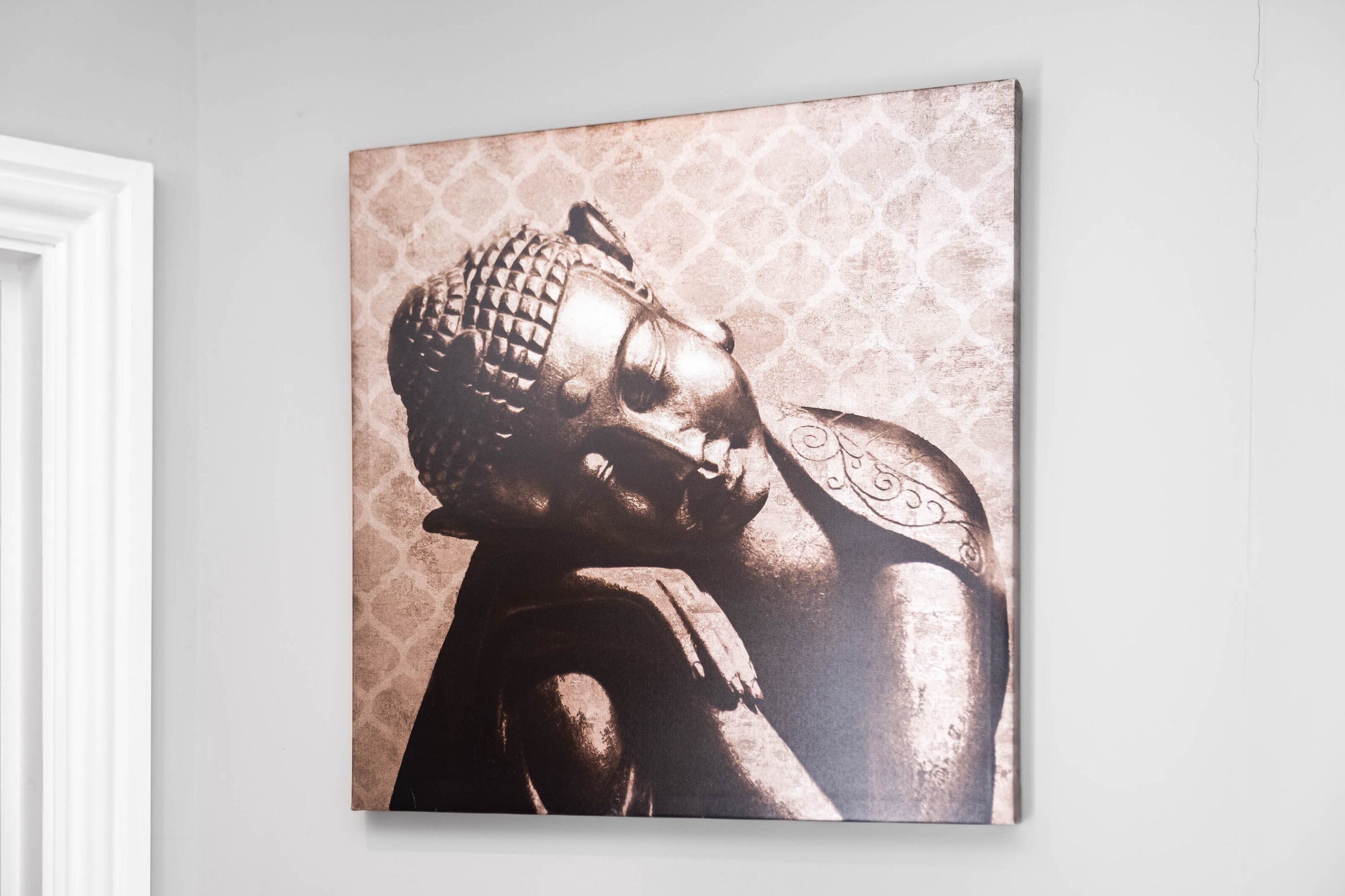 Una obra de arte colgada en la pared que muestra una figura sobre un fondo estampado.