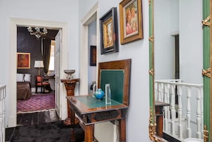A hallway with a wooden desk, a globe, and framed pictures on the wall. - Liston Town House (Kerkira)