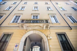 A building with multiple windows, a central archway, and a sign indicating a no parking zone. - Volta House by DM (Como)