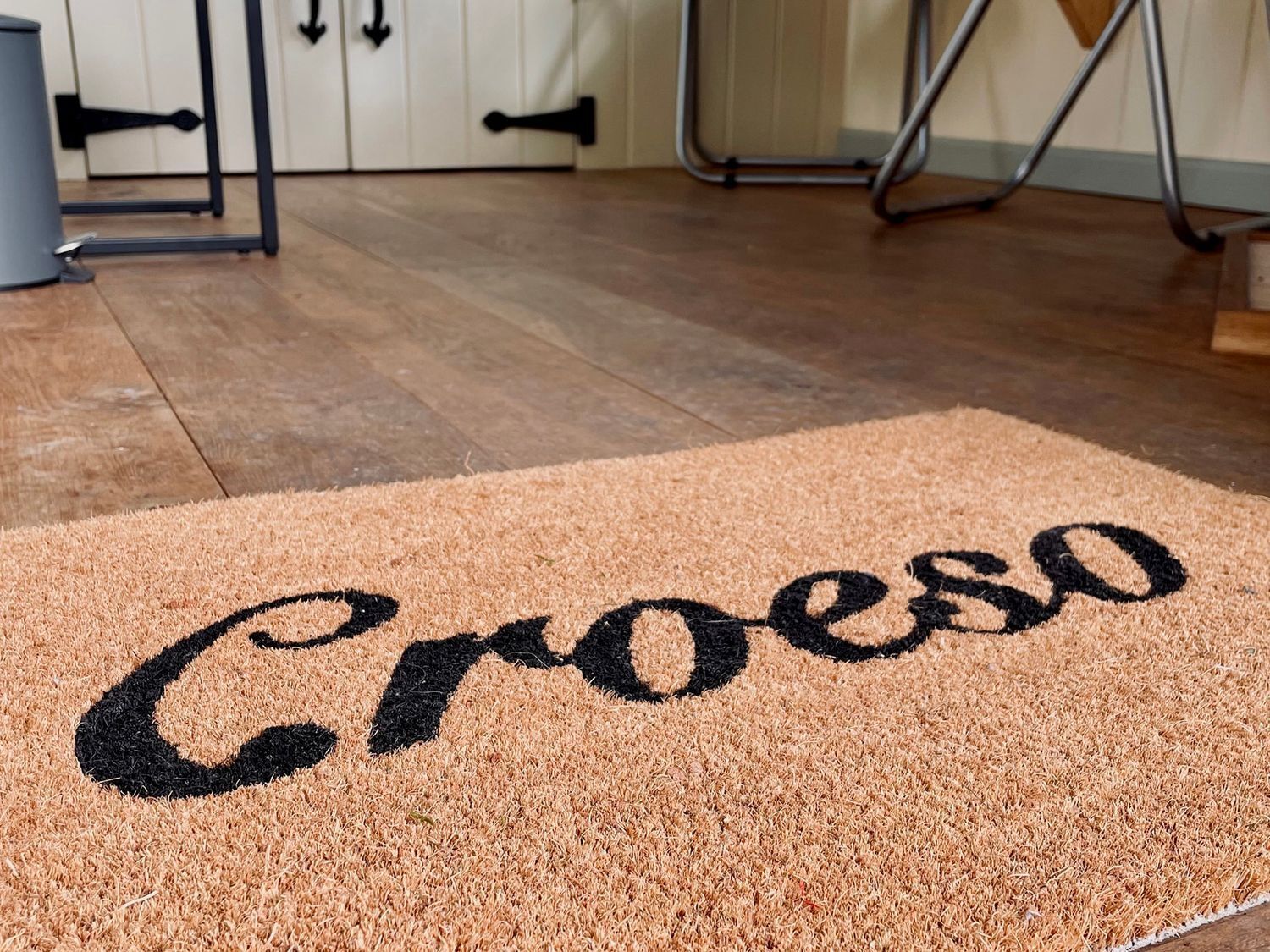 A doormat with the word 'Croeso' on a textured surface.