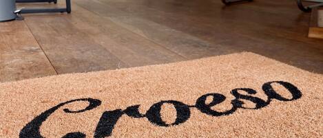 A doormat with the word 'Croeso' on a textured surface.