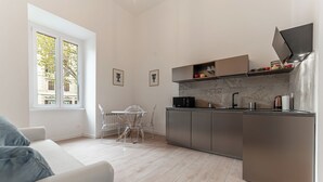 A modern kitchen with a dining area, large windows, and a minimalist design. - Casa Martini - Vatican City (Rome)
