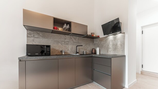 A modern kitchen with a built-in microwave, kettle, and coffee maker. - Casa Martini - Vatican City (Rome)