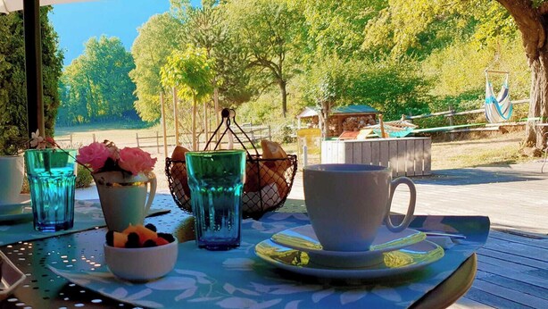 A table set outdoors with a view of trees and a wooden deck. - Family home, a haven of peace at the foot of the Vercors mountains (Vif)
