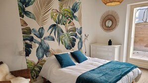 A bedroom with a bed, white dresser, and a wall with tropical leaf wallpaper. - Family home, a haven of peace at the foot of the Vercors mountains (Vif)