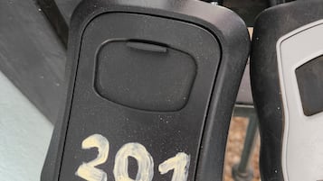 Un candado con el número 201 en una verja metálica.