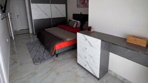 Une chambre à coucher avec un lit, une table de chevet et une commode.