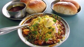 A bowl of food with bread rolls and a small bowl of sauce. - Glitz Nand -Nr Patna Railway Stn (Patna)