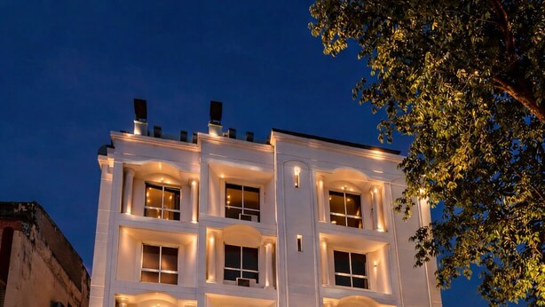 A multi-story hotel with a prominent entrance, a staircase leading to the main entrance, and a well-lit facade. - Glitz Nand -Nr Patna Railway Stn (Patna)