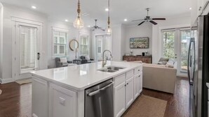 A modern kitchen with a central island, built-in appliances, and pendant lighting. - New 3BR/2.5 LSV Heated Pool - Pearl at Prominence (Santa Rosa Beach)