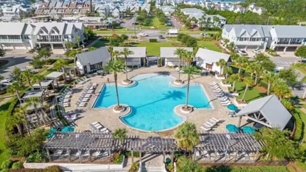 A resort with a central swimming pool, sun loungers, and a view of the surrounding neighborhood. - New 3BR/2.5 LSV Heated Pool - Pearl at Prominence (Santa Rosa Beach)