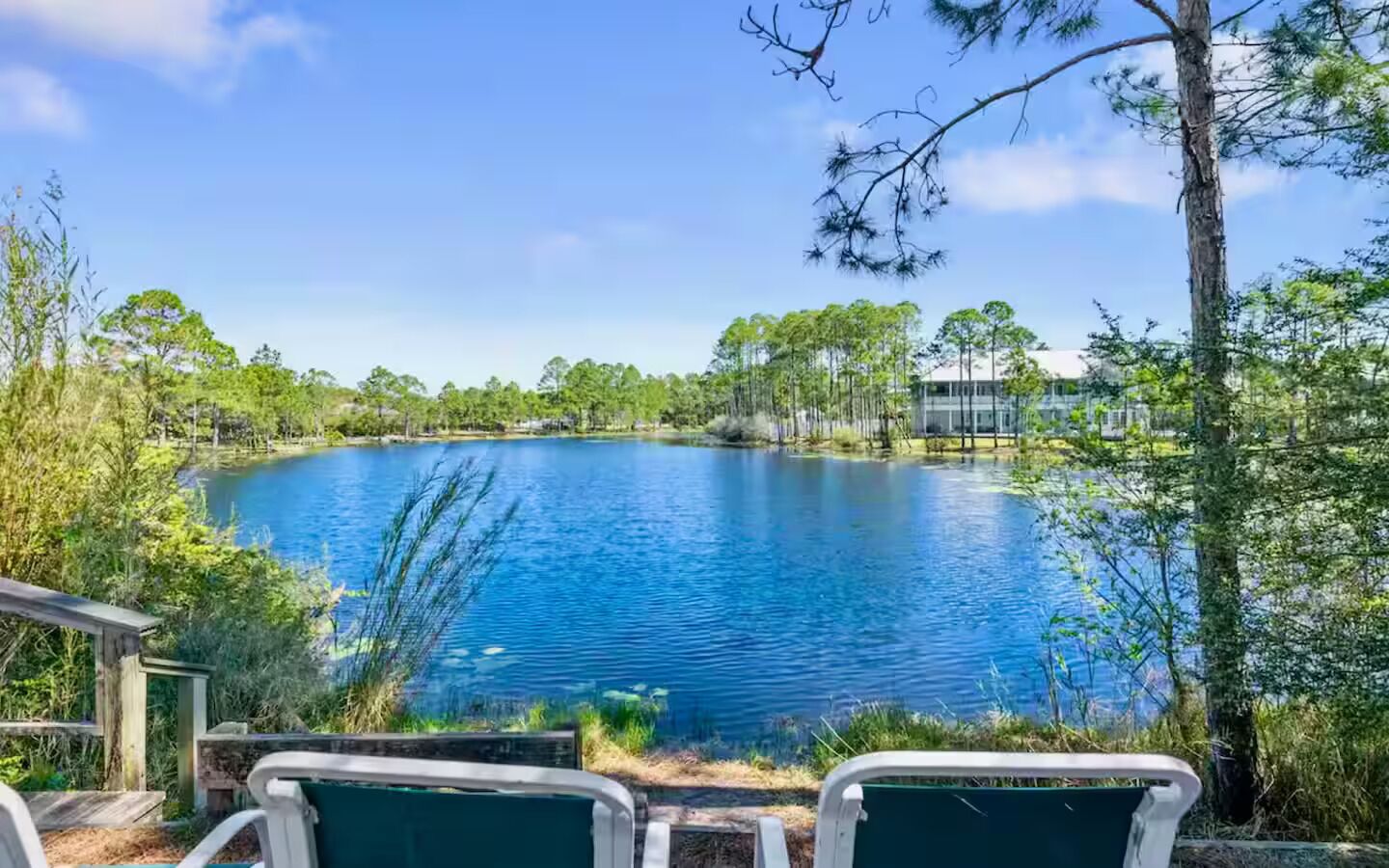 A lake with surrounding trees and a building in the background.